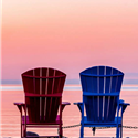 Two deck chairs facing the water