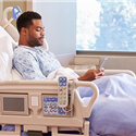 Patient in hospital bed using mobile phone